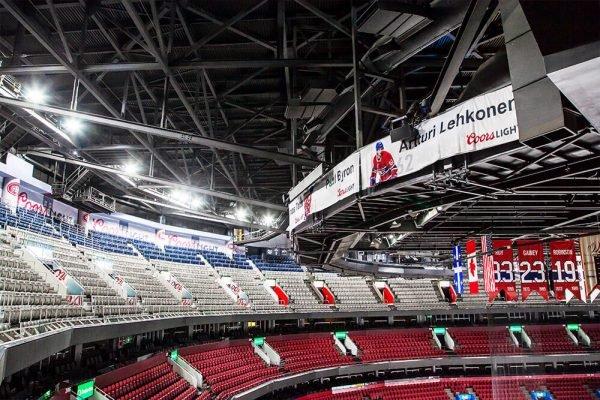a large empty stadium with red seats and a scoreboard